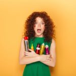 curly hair approved woman holding products