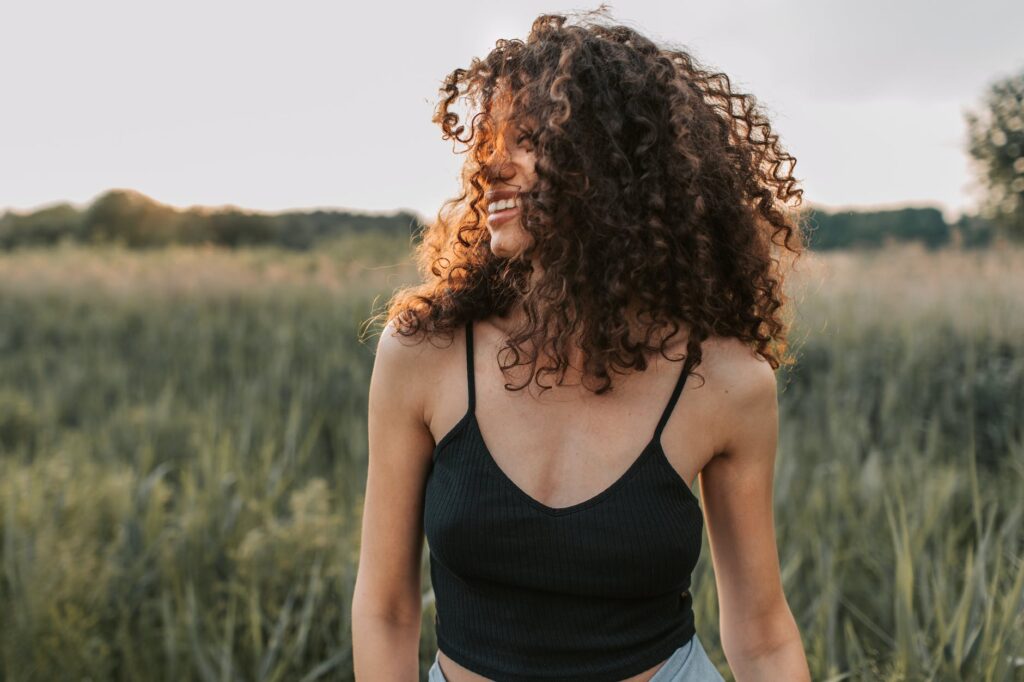 photo of woman with natural curls wearing black tank top summer